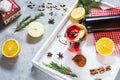 Mulled wine, a bottle of red wine, spruce branches, cinnamon, orange and lemon on white tray on concrete background. Winter drinks Royalty Free Stock Photo