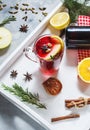 Mulled wine, a bottle of red wine, spruce branches, cinnamon, orange and lemon on white tray on concrete background. Winter drinks Royalty Free Stock Photo