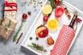 Mulled wine, a bottle of red wine, spruce branches, cinnamon, orange and lemon on white tray on concrete background. Winter drinks Royalty Free Stock Photo