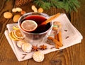 Mulled wine in glass with cinnamon stick, gingerbread and nuts