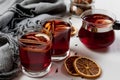 Mulled wine in glasses with orange and spices near gray scarf