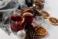 Mulled wine in glasses with orange and spices near gray scarf
