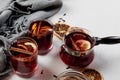 Mulled wine in glasses with orange and spices near gray scarf