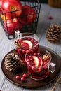 Mulled wine in glasses on a wooden background. Apples, cranberries, cinnamon, star anise. Royalty Free Stock Photo