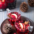 Mulled wine in glasses on a wooden background. Apples, cranberries, cinnamon, star anise. Royalty Free Stock Photo