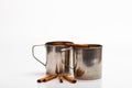 Mulled wine or hot beverage in metal mugs with cinnamon sticks. Mugs with mulled wine or hot drink and cinnamon aroma