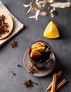 Mulled wine with orange, apple and cinnamon in glass on a dark background. The concept of a traditional winter hot drink with Royalty Free Stock Photo