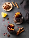Mulled wine with orange, apple and cinnamon in glasses on a dark background. The concept of a traditional winter hot drink with Royalty Free Stock Photo