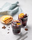 Mulled wine with orange, apple and cinnamon in glasses on a light background. The concept of a traditional winter hot drink Royalty Free Stock Photo
