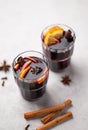 Mulled wine with orange, apple and cinnamon in glasses on a light background. The concept of a traditional winter hot drink with Royalty Free Stock Photo