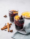 Mulled wine with orange, apple and cinnamon in glasses on a light background. The concept of a traditional winter hot drink with Royalty Free Stock Photo