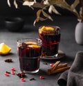 Mulled wine with orange, apple, pomegranate and cinnamon in glasses on a dark background. The concept of a traditional winter hot Royalty Free Stock Photo