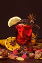 Mulled wine with orange, cloves, anise and cinnamon on brown.
