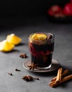 Mulled wine with orange, pomegranate and cinnamon in glass on a dark background. The concept of a traditional winter hot drink Royalty Free Stock Photo