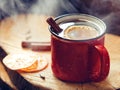 Mulled wine in a red ceramic mug over rustic wooden boards Royalty Free Stock Photo