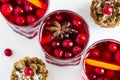 Mulled wine in small glasses with cranberries, anise and oranges. White background, top view Royalty Free Stock Photo