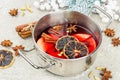 Mulled wine with spices in a pot with traditional Christmas decor. Hot beverage, festive background Royalty Free Stock Photo