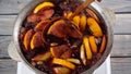 mulled wine thar stiring wooden spoon, preparing in kettle on stove