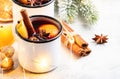 Mulled wine in white metal mugs with cinnamon, spices and orange with fir tree and christmas lights - traditional drink on winter Royalty Free Stock Photo