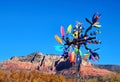 Multi-blade colorful art glass windmill with mountain, blue sky Royalty Free Stock Photo