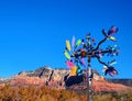 Multi-blade colorful art glass windmill with mountain, blue sky Royalty Free Stock Photo