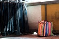 Multi color on Plastic sack and the row of denim pants hanging on trempels of Flea market