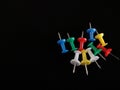 Multi color push pin thumb tacks isolated on dark black Royalty Free Stock Photo