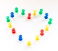 Multi color thumb-tacks arranged in heart shape. Royalty Free Stock Photo