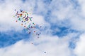Multi-Colored Ballons Floating in a Cloudy Blue Sky Royalty Free Stock Photo