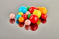 Multi colored balls of chewing gum on a gray background with reflection