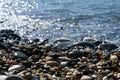 Beach stones and sea water in sunlight Royalty Free Stock Photo