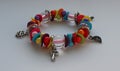 Multi-colored beads and silver charms in one wrist bracelet isolated on white angle view