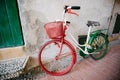 a multi-colored bicycle of an old model stands by the wall