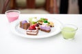 Multi-colored biscuit cakes on a white plate with berry mousse in glasses. Celebration, breakfast, baby food. Top view at an angle Royalty Free Stock Photo