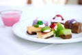 Multi-colored biscuit cakes on a white plate with berry mousse in glasses. Celebration, breakfast, baby food. Top view at an angle Royalty Free Stock Photo