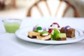 Multi-colored biscuit cakes on a white plate with berry mousse in glasses. Celebration, breakfast, baby food. Top view at an angle Royalty Free Stock Photo