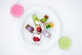 Multi-colored biscuit cakes on a white plate with berry mousse in glasses. Celebration, breakfast, baby food. Top view Royalty Free Stock Photo