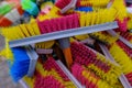 Multi-colored bright brushes, mops for manual cleaning of premises from dust and dirt. Artificial pile plastic handles