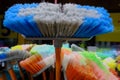 Multi-colored bright brushes, mops for manual cleaning of premises from dust and dirt. Artificial pile  plastic handles Royalty Free Stock Photo