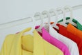 Multi-colored bright jackets on a hanger on a white background