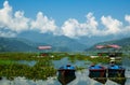 Multi-colored bright wooden boats tied in the grass to the shore of Phewa Lake, in Pokhara Nepal Royalty Free Stock Photo