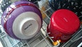 multi-colored ceramic bowl and enamel mug inside an open dishwasher