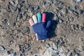 Multi-colored children`s glove lies on ground