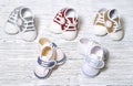 multi-colored children`s shoes on a white-gray non-uniform wooden background Royalty Free Stock Photo