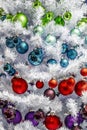 Multi-colored Christmas balls on a Christmas tree with white needles, close-up Royalty Free Stock Photo