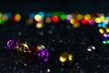 Multi-colored Christmas jingle bells. Black blurred bokeh background.