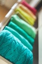 Multi-colored clothes folded vertically in a wardrobe drawer. The concept of order and storage