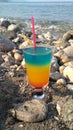 Multi colored cocktail with a straw drunk on the beach of Antalya.