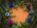 Multi-colored cones with sprigs of spruce on a wooden surface.