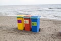 multi-colored containers for sorting garbage are on the beach ag